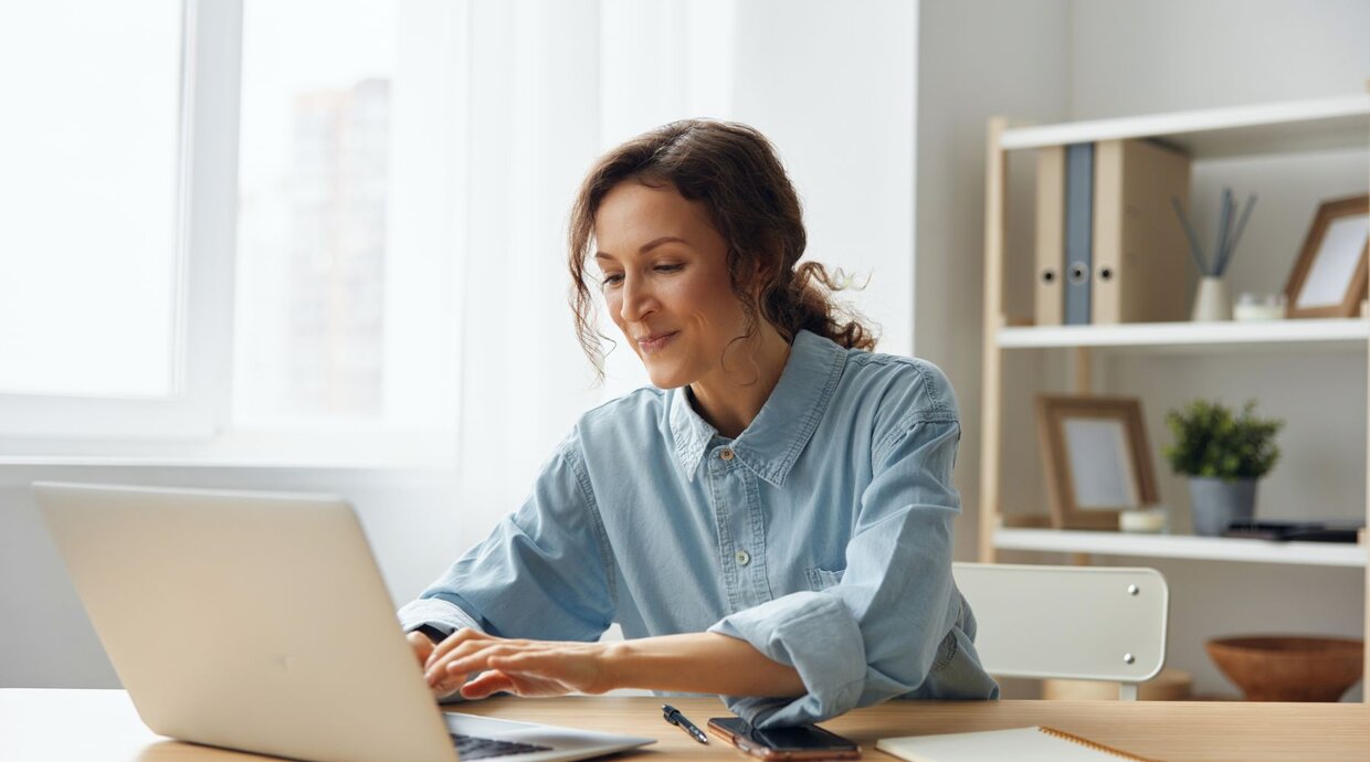 Frau sitzt hinter ihrem Laptop